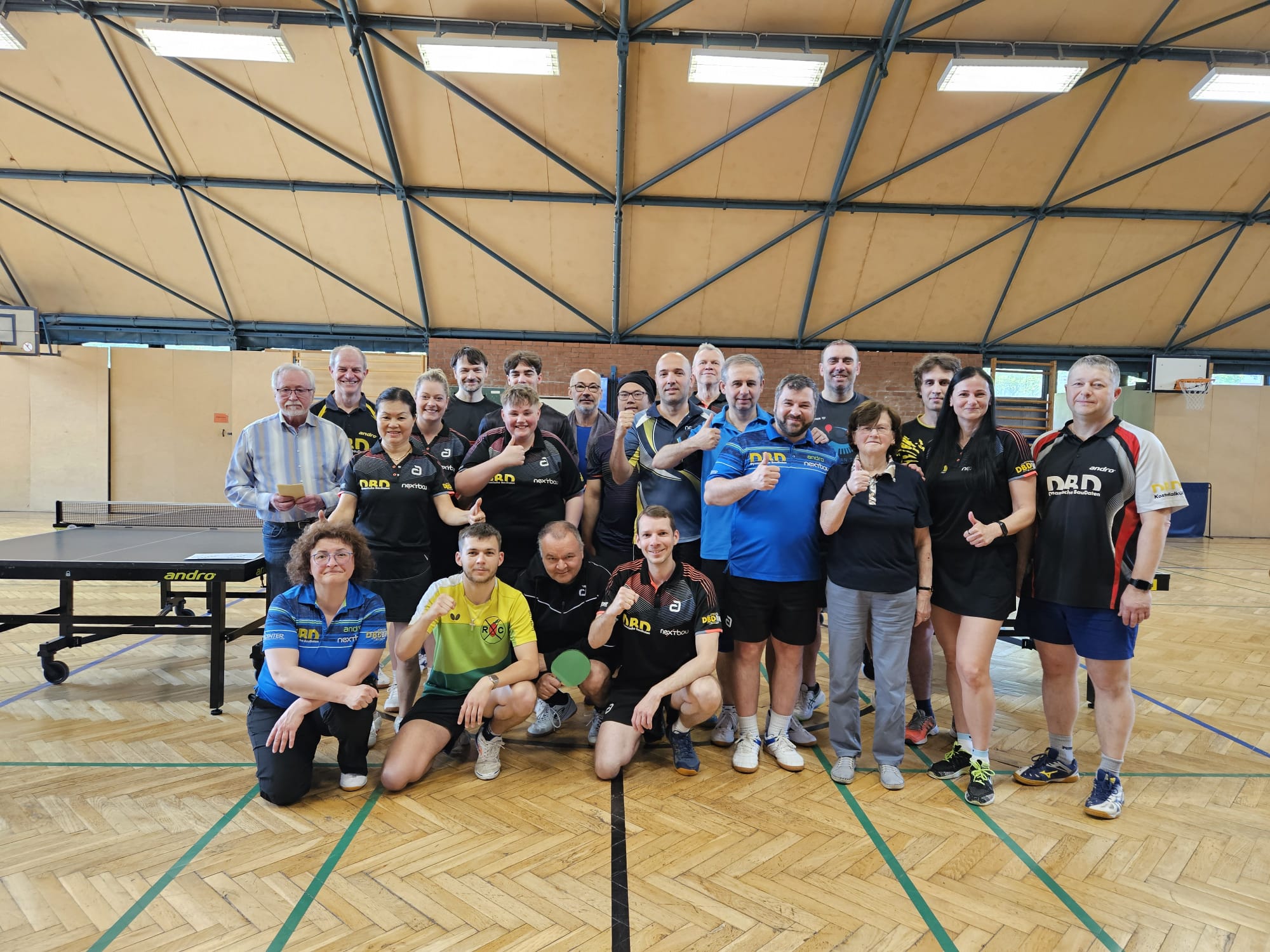 Gruppenfoto von 21 Vereinsmitgliedern, die die Faust heben
